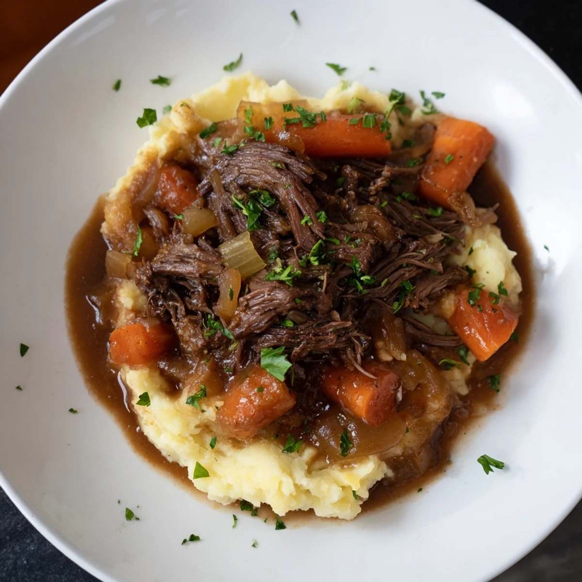 Tender slow cooker pot roast with carrots, celery, and mashed potatoes, ready to serve.