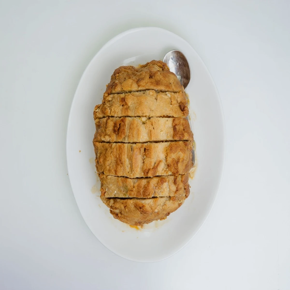Golden-brown Effortless Stove Top Stuffing Meatloaf, ready to slice, served warm and steamy.