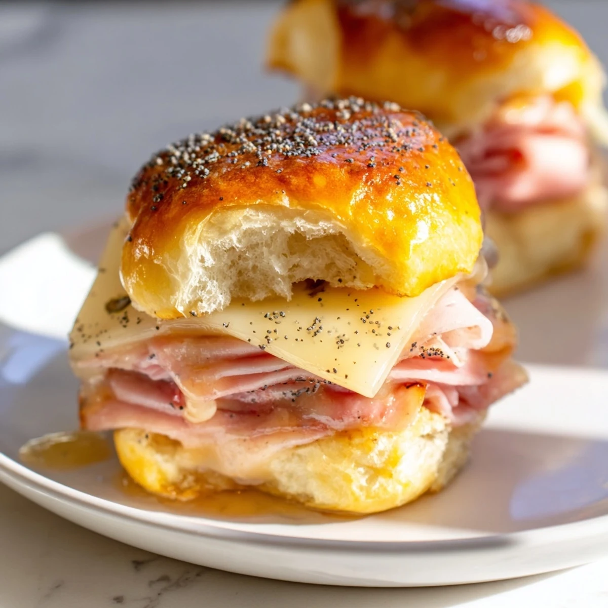 Golden-brown Budget-Friendly Ham & Cheese Sliders, showcasing layers of melty cheese and juicy ham.