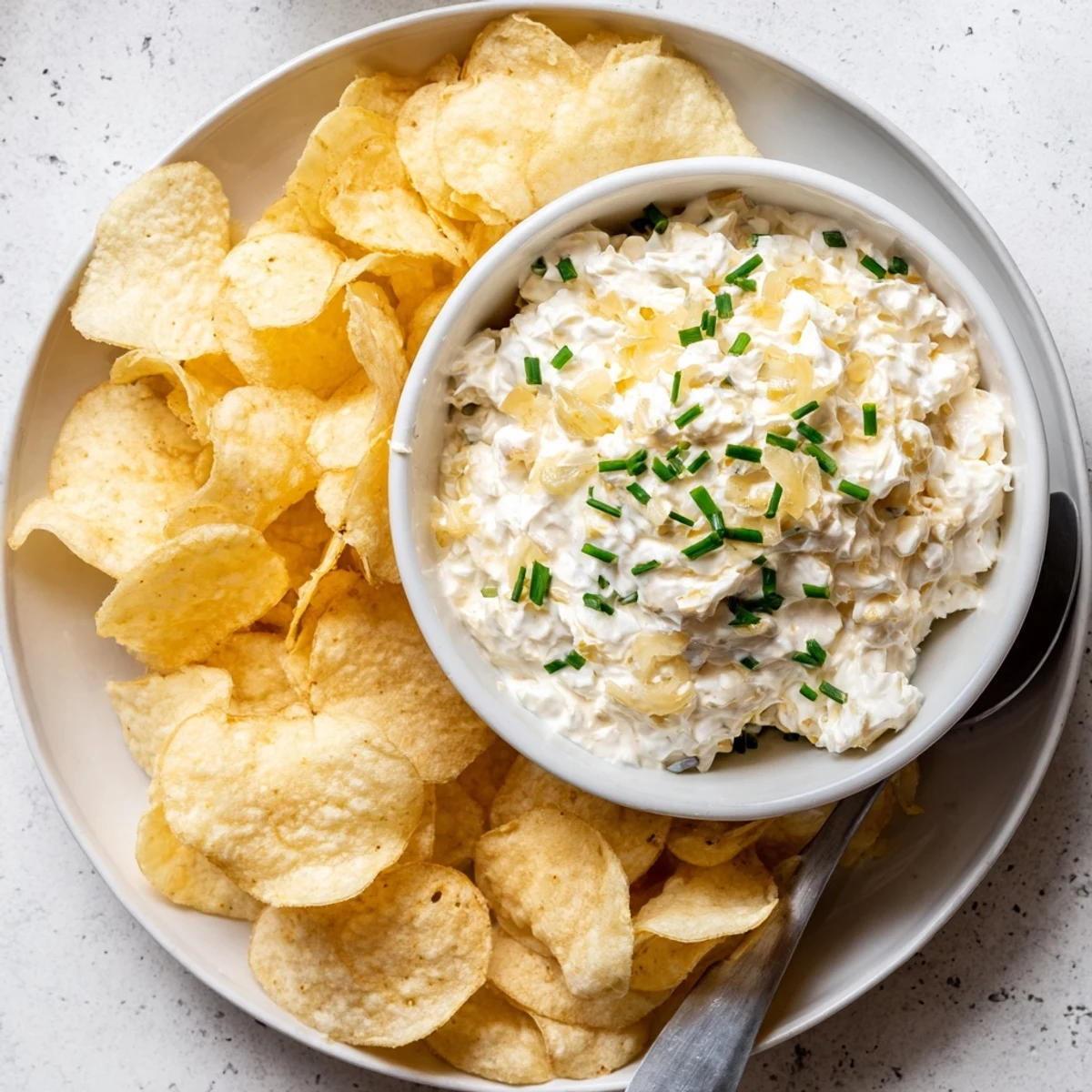 A close-up of potato chips with onion dip, a classic American recipe, ready to eat.