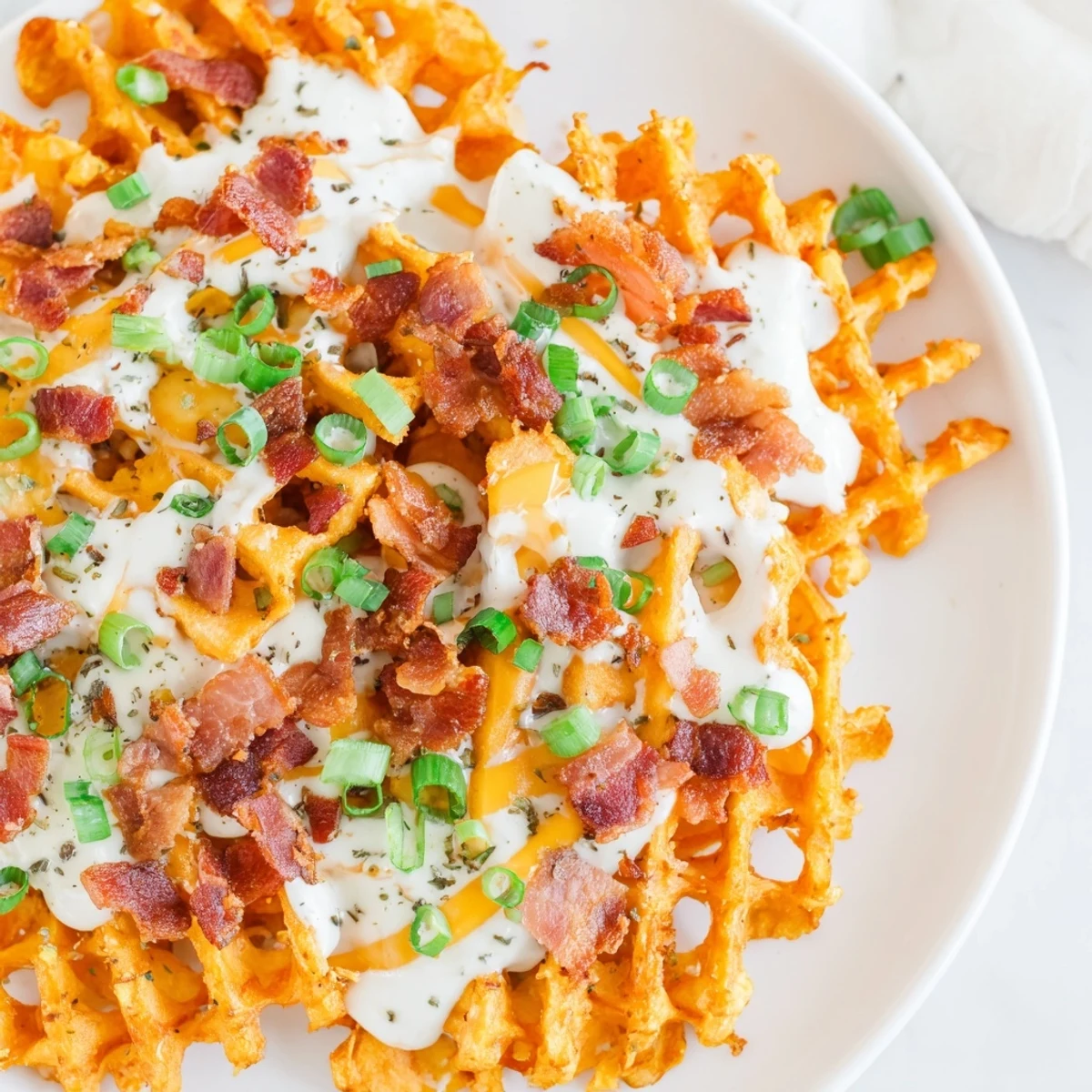 Golden, crispy Loaded Sweet Potato Fries topped with melted cheddar cheese and savory bacon bits.