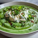 Green spring pea soup topped with creamy ricotta and refreshing mint drizzle.