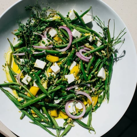 A refreshing English Ivy salad, featuring crisp green beans and snap peas topped with sharp white cheddar.