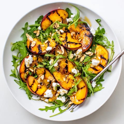 Honey-lemon dressing glistens on this Grilled Peach & Arugula Salad, a fresh summer dish.