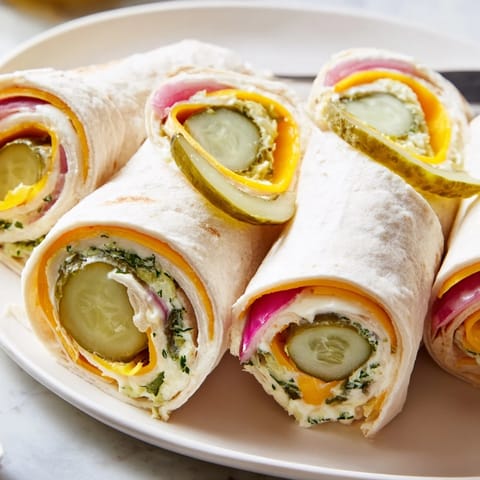 Delicious pickle-in-a-blanket appetizers served with mustard and fresh dill garnish.  