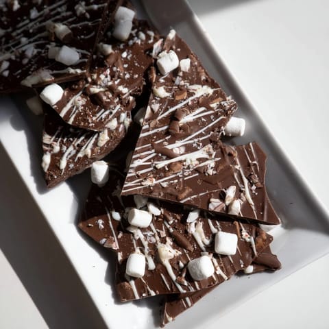 Melted semisweet chocolate transformed into Hot Chocolate Bomb Bark, a visually appealing holiday treat.