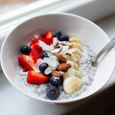 Thick homemade chia seed pudding topped with crunchy nuts and shredded coconut.