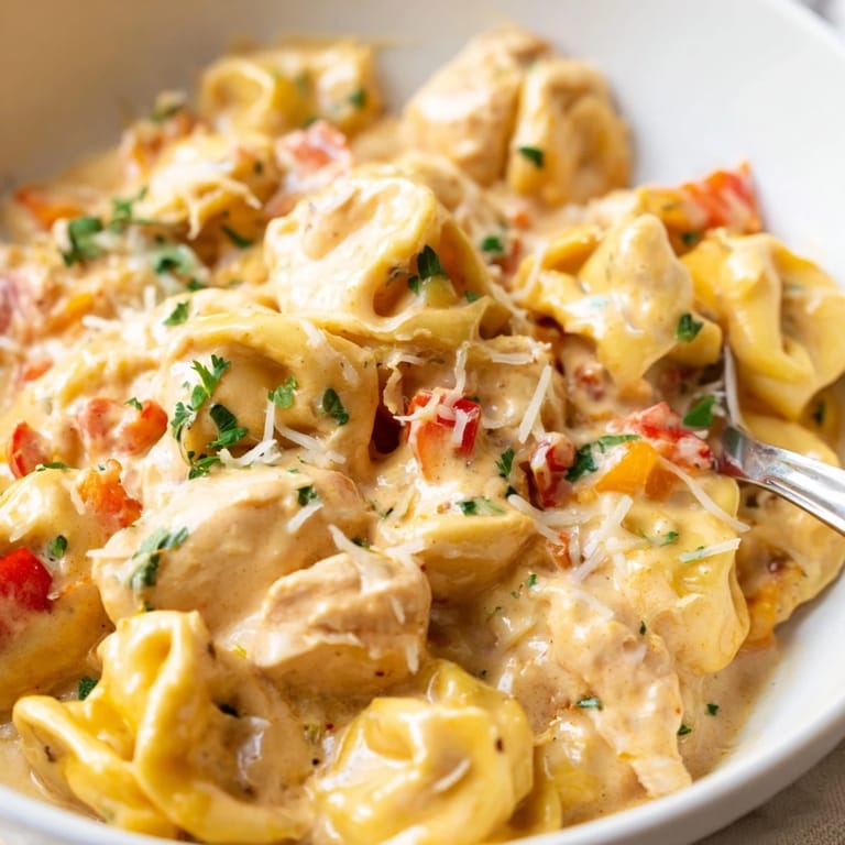A bowl of Zesty Cajun Garlic Parmesan Chicken Tortellini bursting with flavors and textures.  