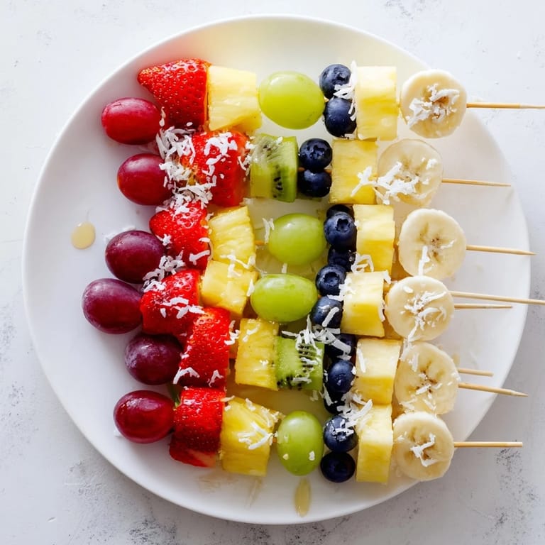 A colorful serving of Easy Festive Fruit Kabobs, featuring juicy pineapple with sweet blueberries and kiwi.