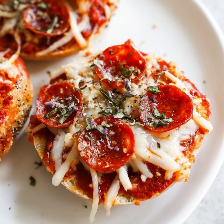 Close-up of bubbling, cheesy mini pepperoni pizza bagels ready to eat as an easy, American appetizer.